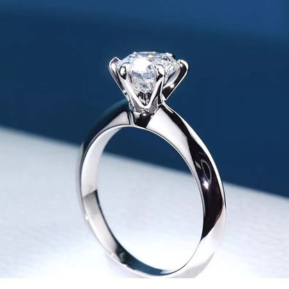 Lyra Round Moissanite Solitaire Ring is a perfect diamond alternative. Set in a 6-prong setting with high quality sterling silver plated in white gold. This ring is sure to dazzle as moissanite gemstone has even more fire than diamond. The beautiful ring comes in a variety of stone sizes for you to choose from.