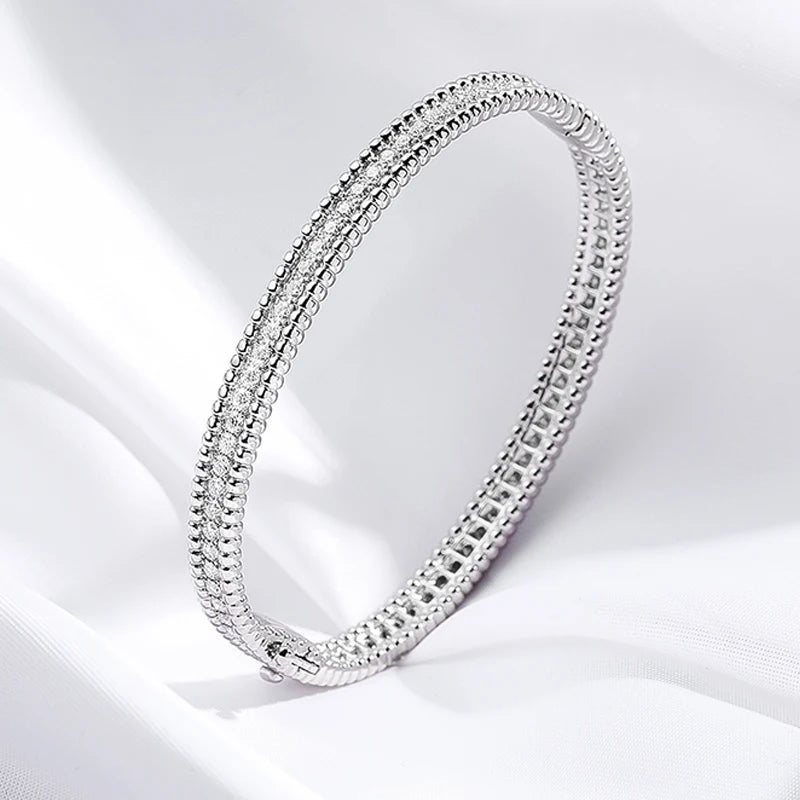 Introducing the Stella Moissanite Bangle: a luxurious piece crafted with 2.28CT of brilliant moissanite stones, set in sterling silver plated with 18K white gold in a secure 4-prong setting. Its timeless elegance and durability make it perfect for special occasions, while its superior shine rivals that of diamonds. Elevate your style with this stunning, environmentally conscious jewelry choice from Elejoux.